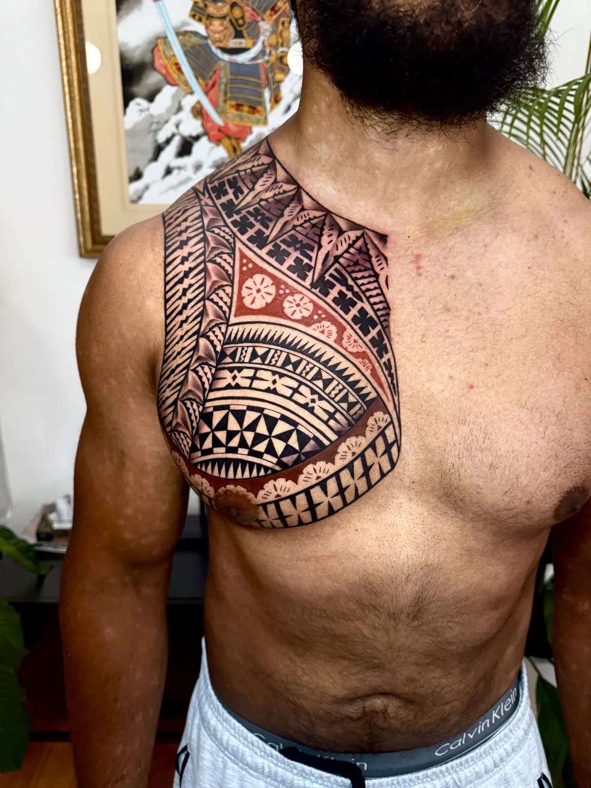 Traditional Polynesian chest piece by Ameo Bolaira, dense blackwork panels across the chest and shoulder