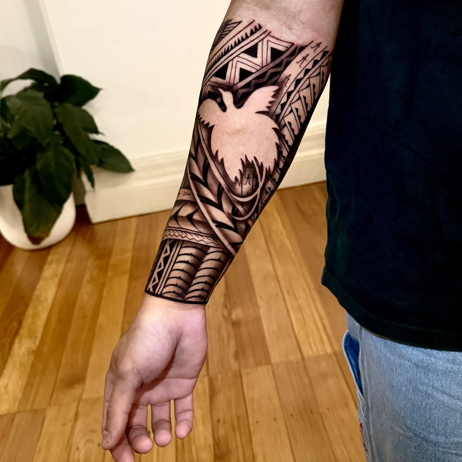 Fijian tattoo artist Ameo tattooing a black Polynesian pattern sleeve on a client's forearm at Memento studio in Newtown, Sydney
