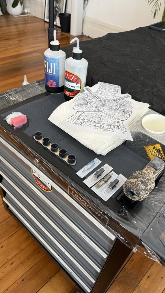 Tattoo station set up with inks, stencil, needles and equipment ready for a session