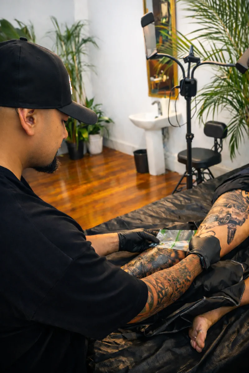 A fresh tattoo being wrapped in second-skin film at the end of a session